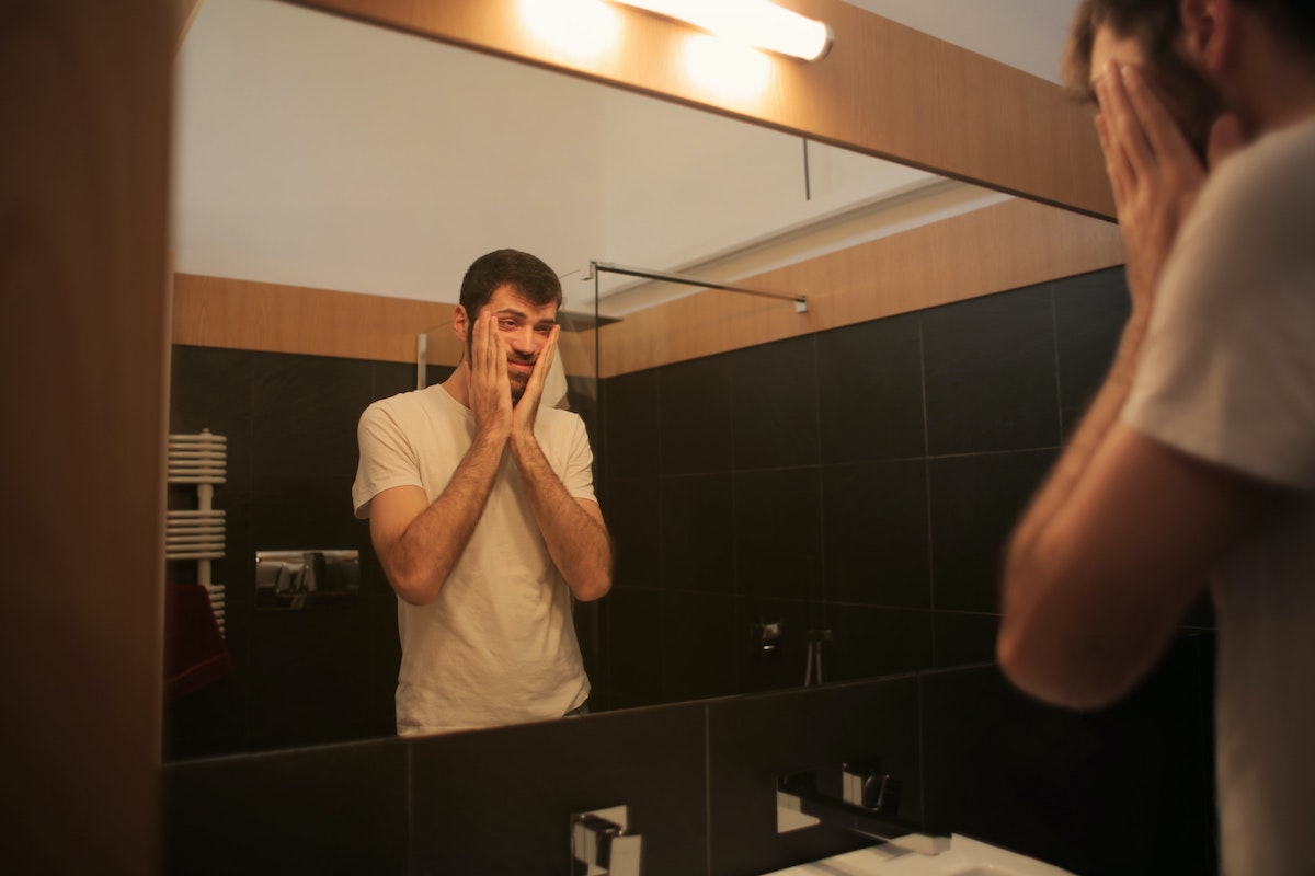 a man looking upset in the mirror