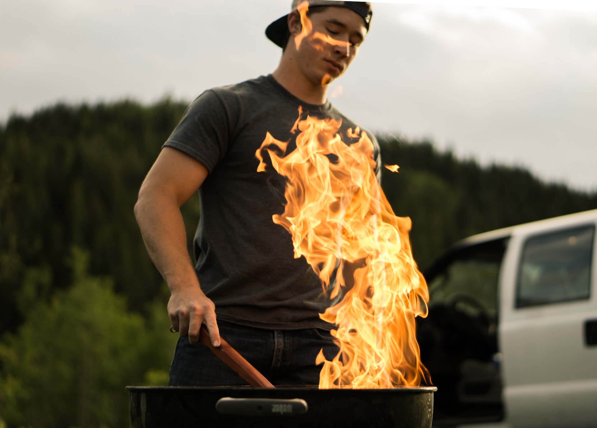 Man grilling over large flame