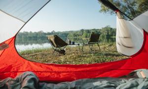 The view from an MSR tent looking out over camping chairs and a lake.