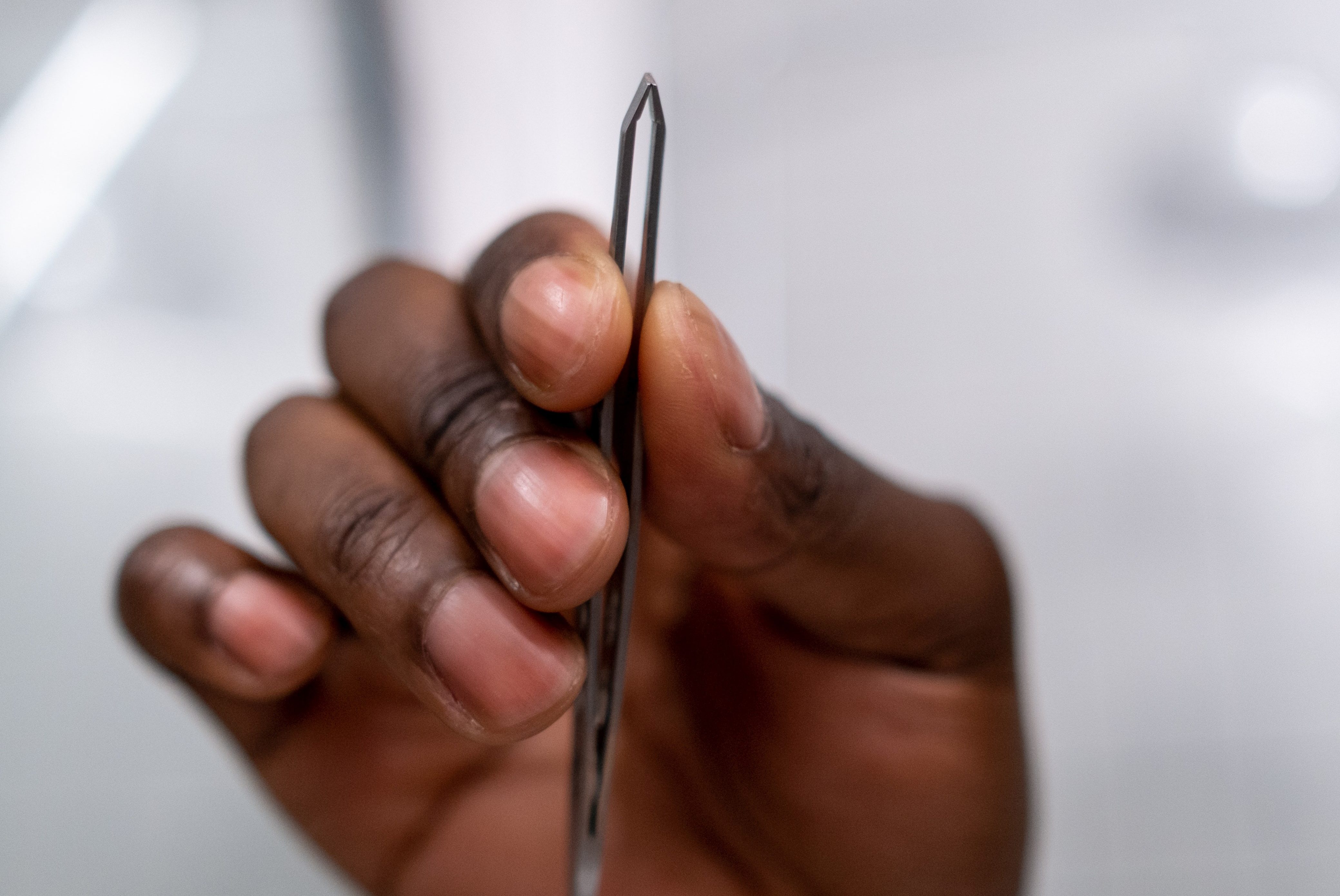 Person's hand holding tweezers