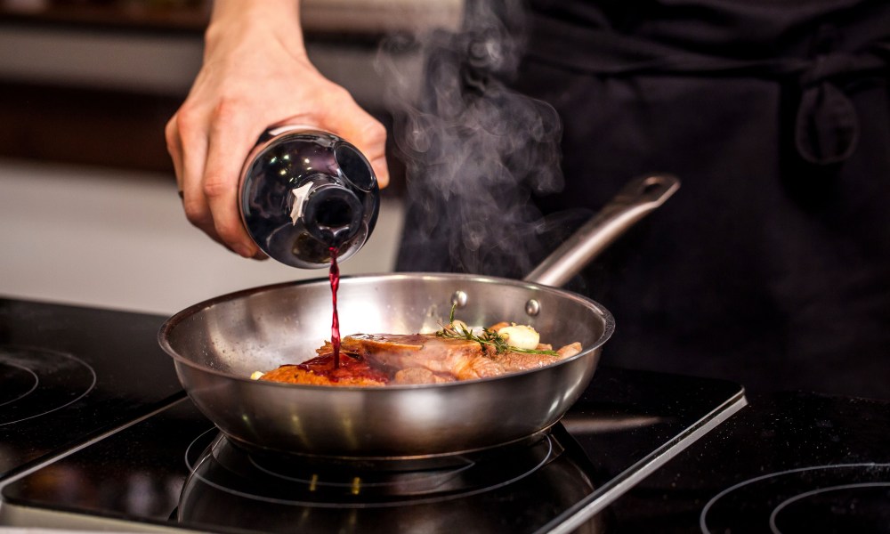 man cooking with wine