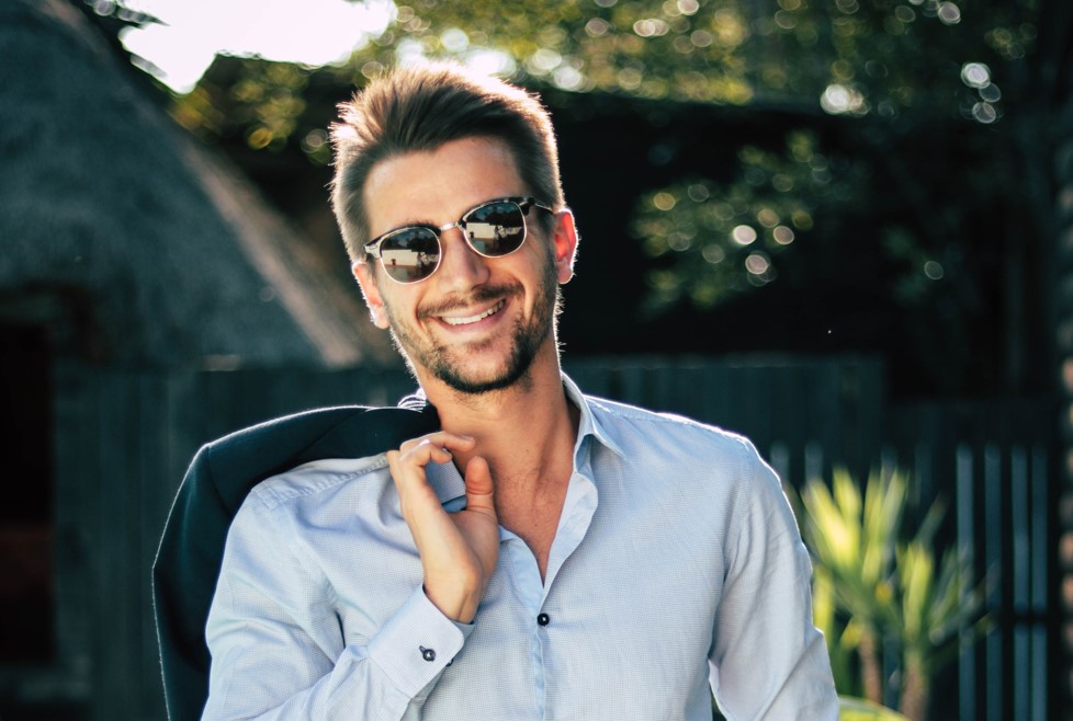 https://www.themanual.com/wp-content/uploads/sites/9/2023/08/Man-in-round-sunglasses-with-jacket-on-his-shoulder.jpg?fit=800%2C537&p=1