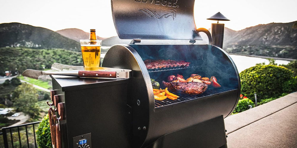 The Traeger Grills Pro Series 22 Electric Wood Pellet Grill and Smoker outdoors with food cooking inside it.