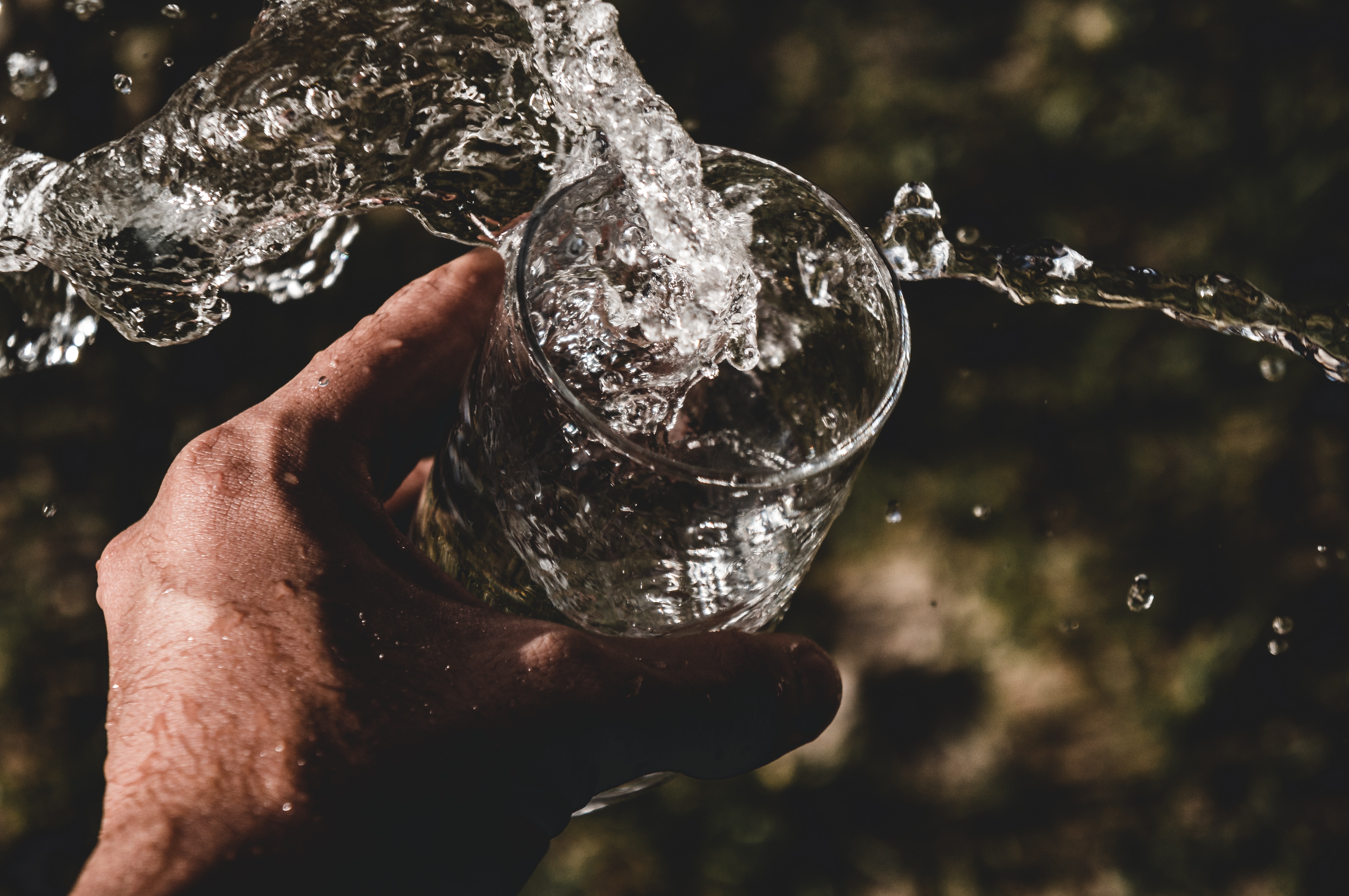 Hand holding glass of water hydration splash