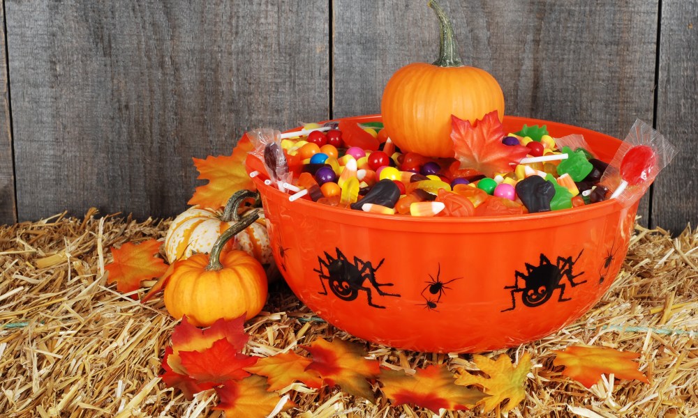 bowl of halloween candy with fall leaves