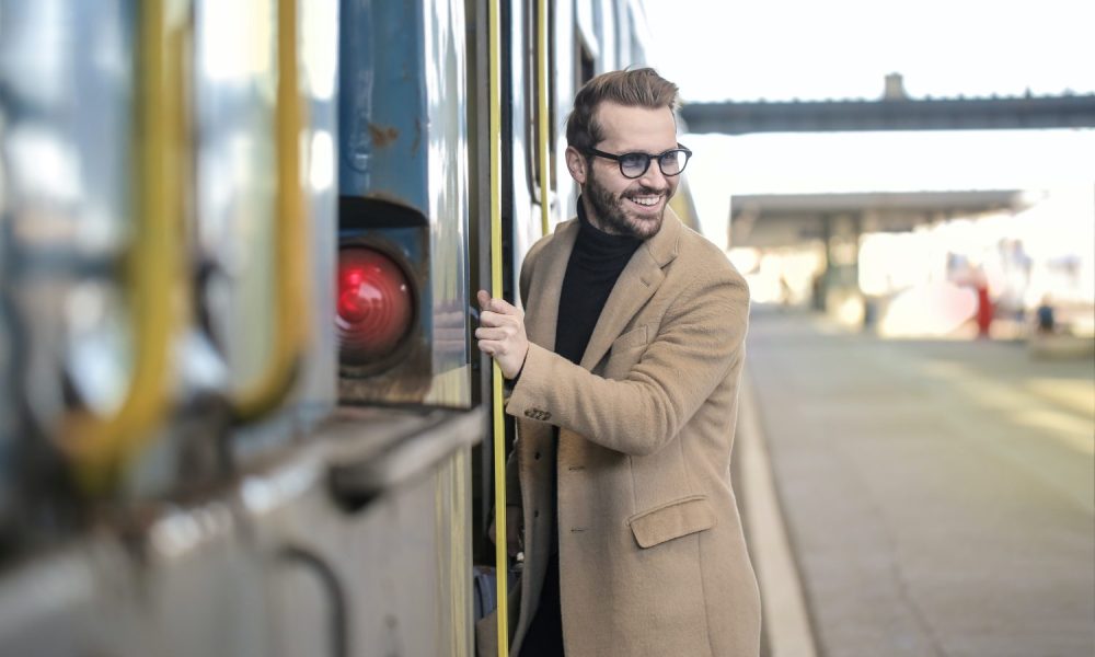 Man in cashmere coat getting on a train