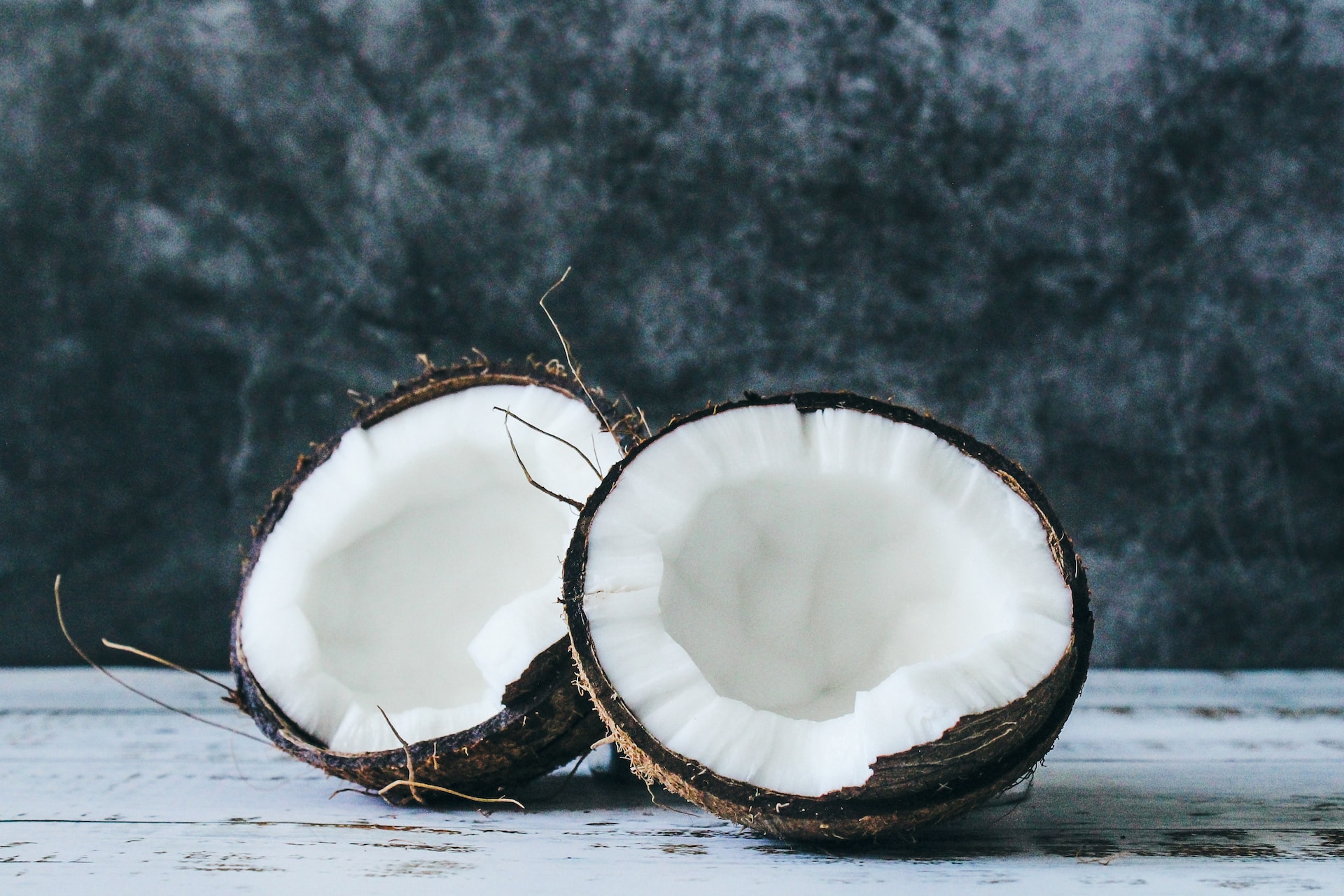 Open coconut split in half with dark background