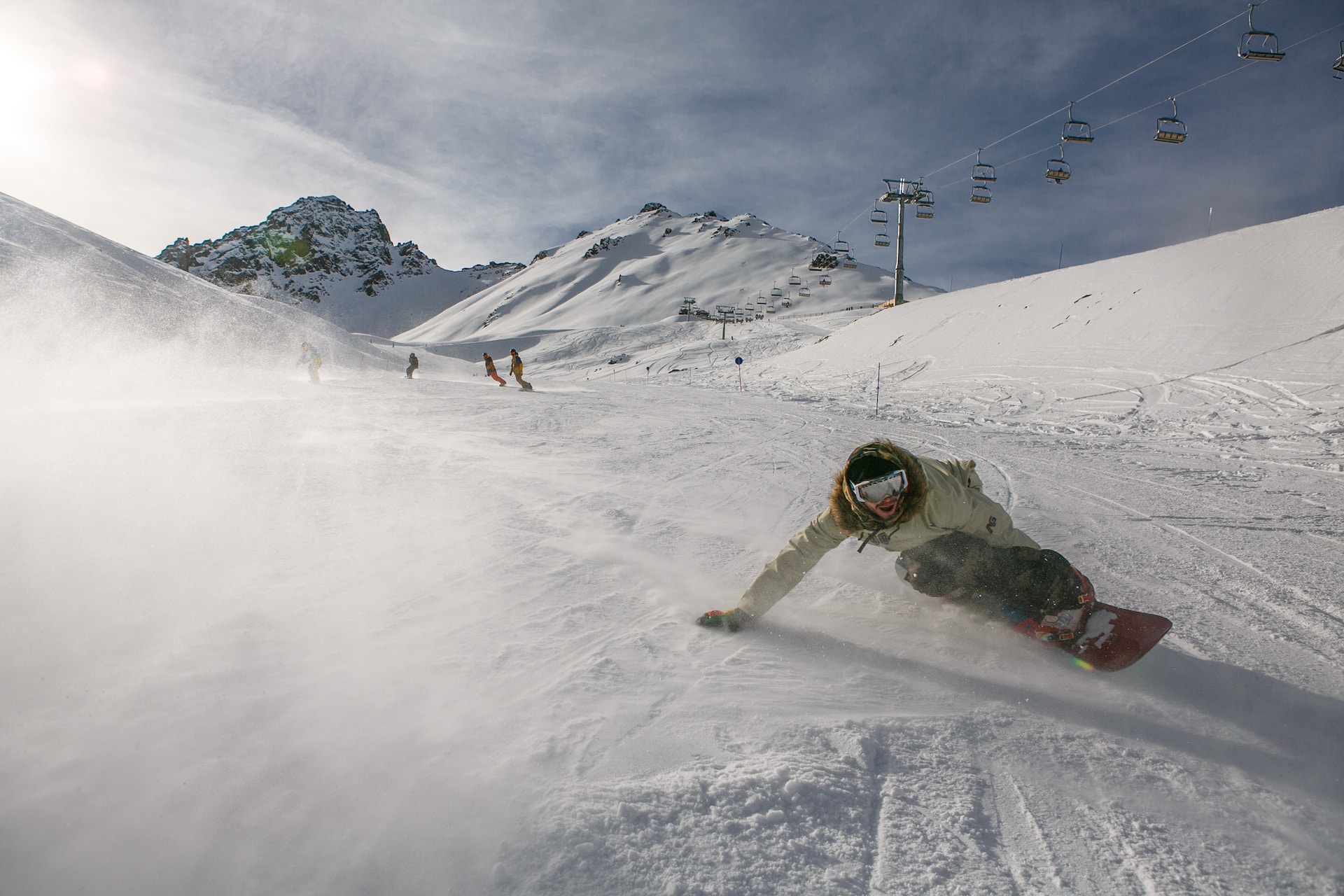 A man snowboarding on a groomer.