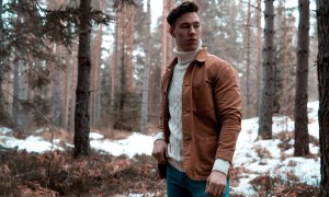 Man in a turtleneck standing in the woods