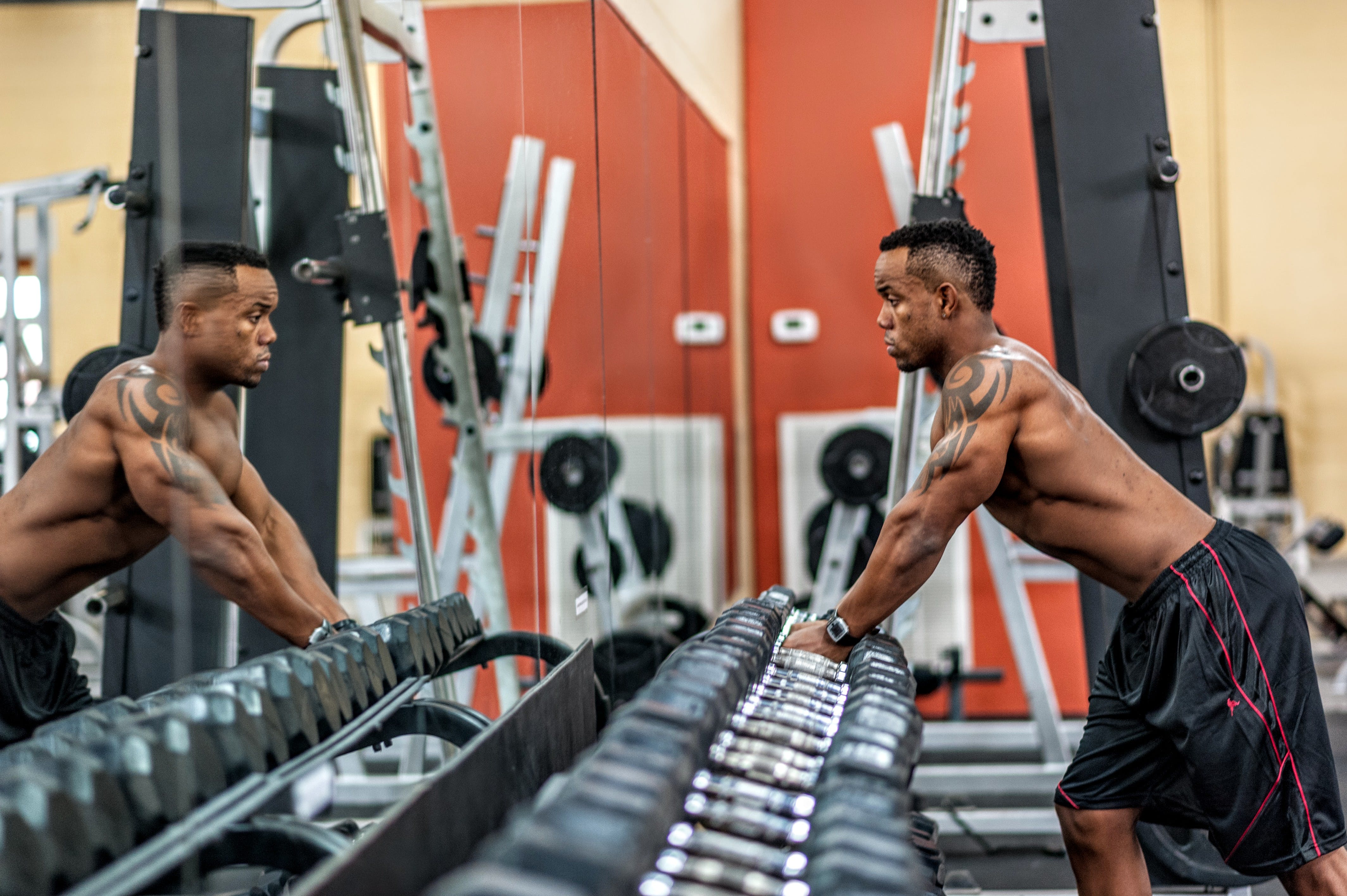 Man in a gym watching himself in the mirror