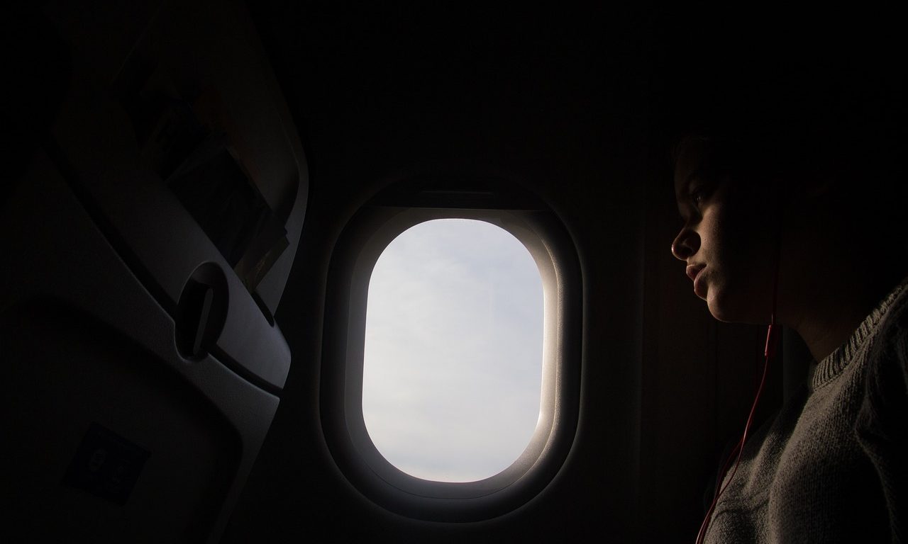 person looking out plane window