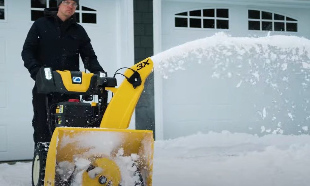 A man uses the Cub Cadet 3X 30-inch IntelliPOWER Snow Blower to clear his wet, heavy snow.