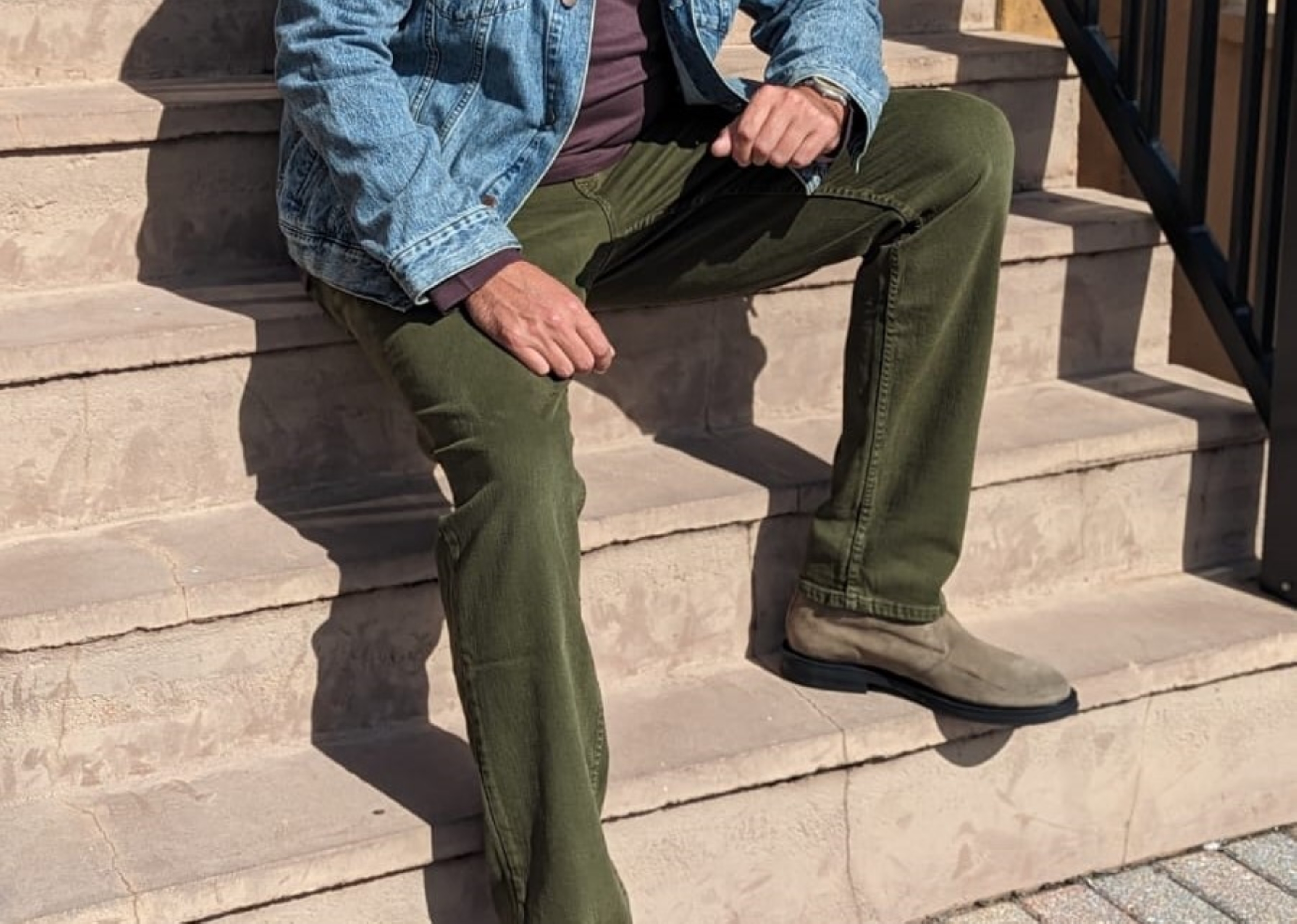 Man sitting on steps in jeans and chukkas