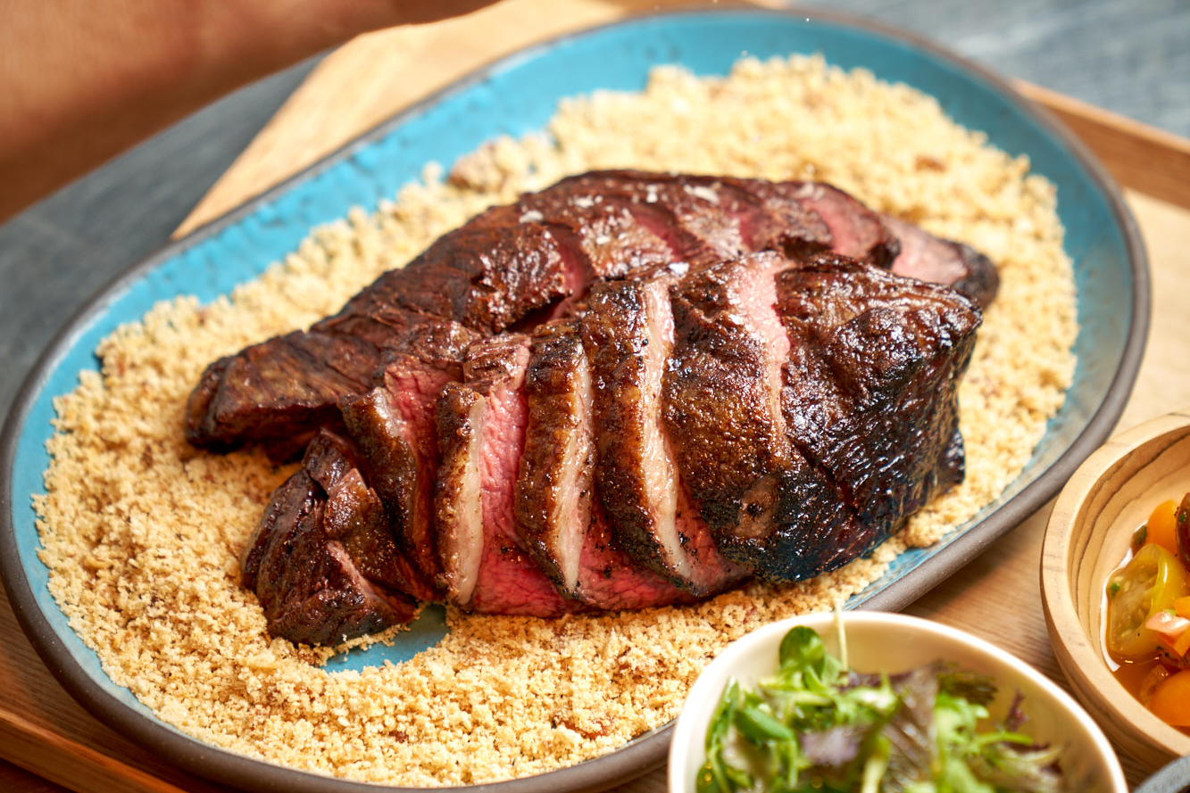 Sliced picanha steak on plate.