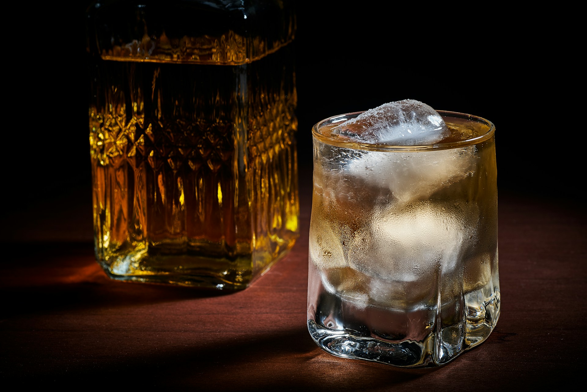 Whiskey in glass next to the bottle