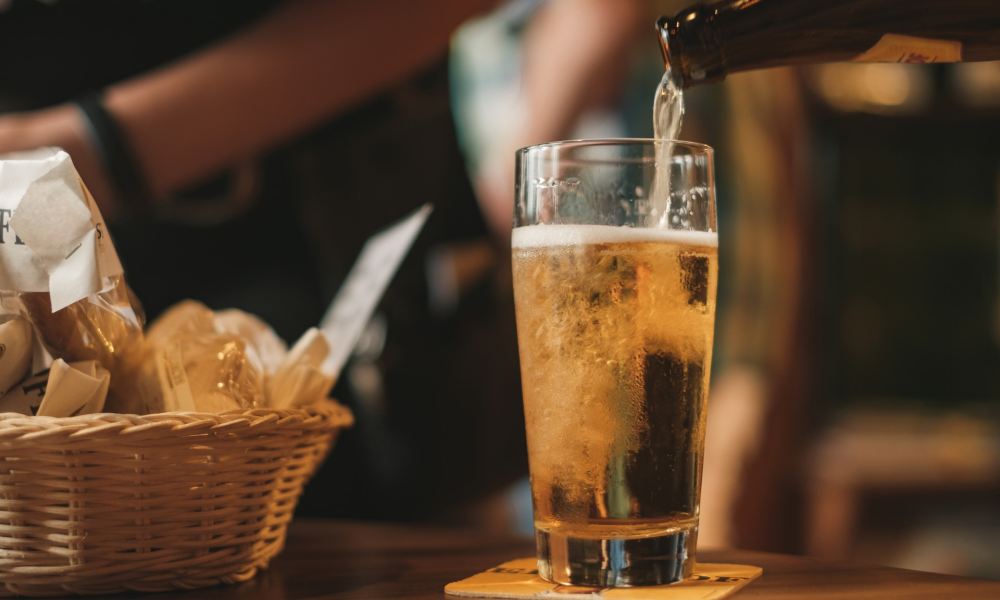 Pouring beer with chips in the background