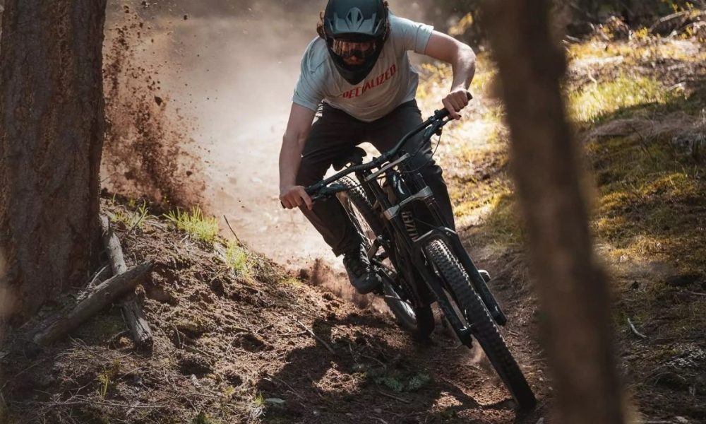 A man riding a Specialized mountain bike down a difficult trail.