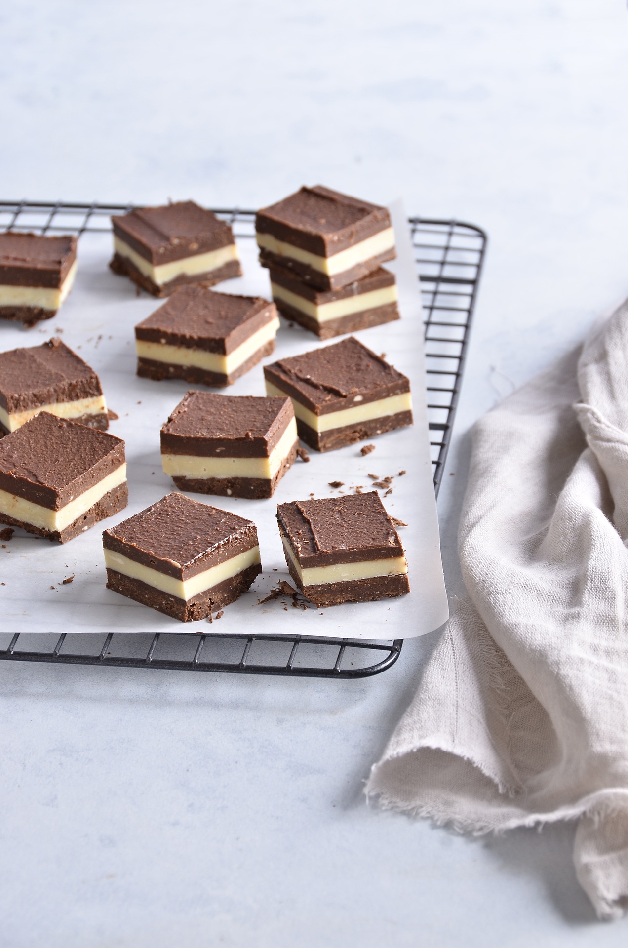 chocolate cream dessert bites squares on baking tray cooking tray on white table