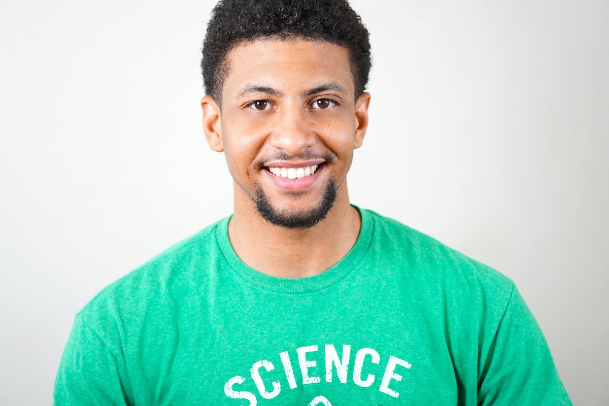 a man in a green shirt smiling