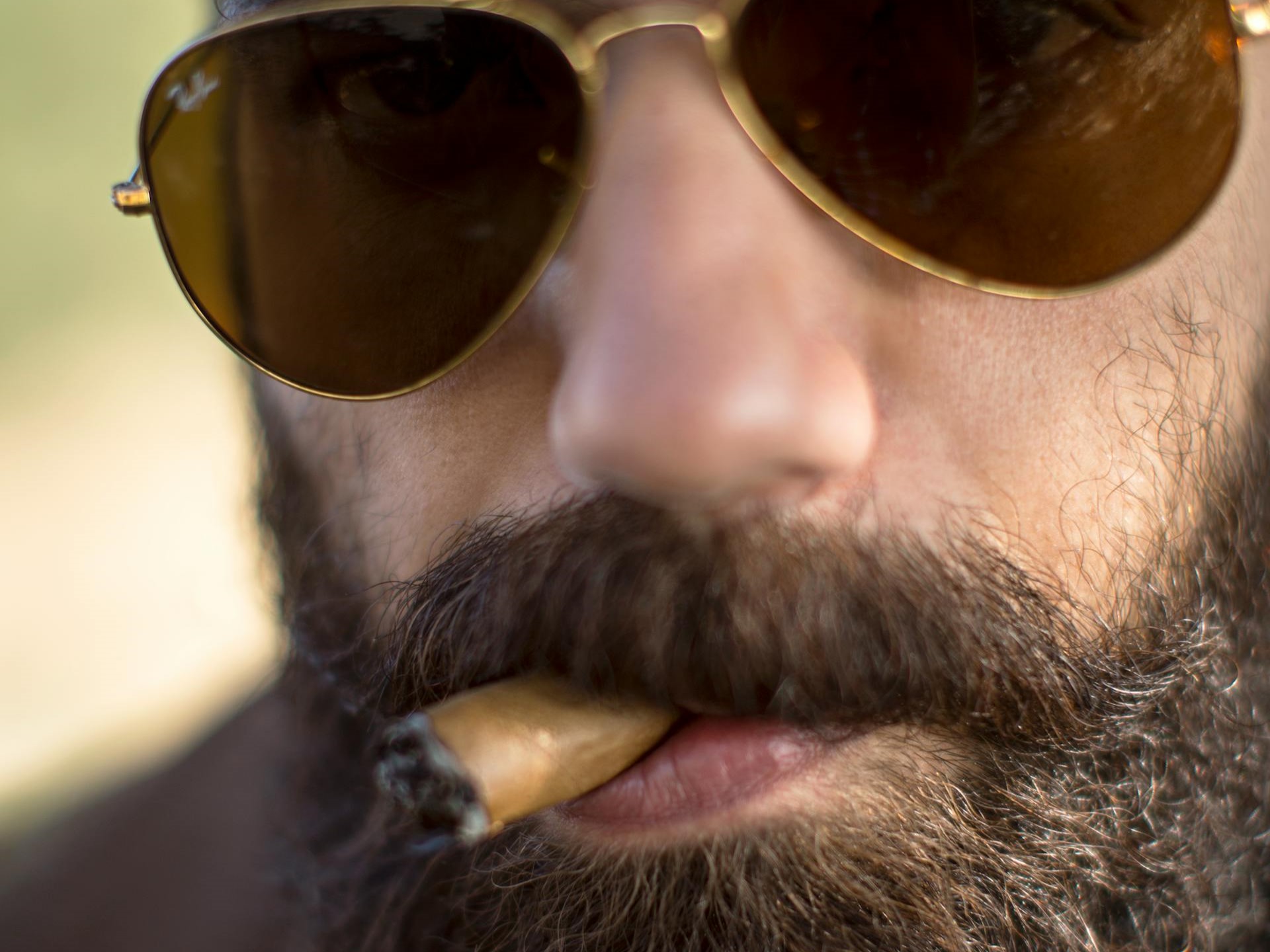 close up of bearded man smoking a cigar by nishant aneja from