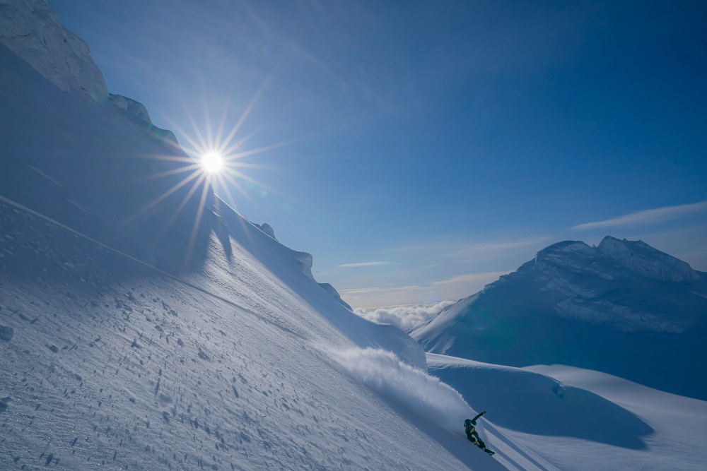 Snowboarder in powder field, Alaska