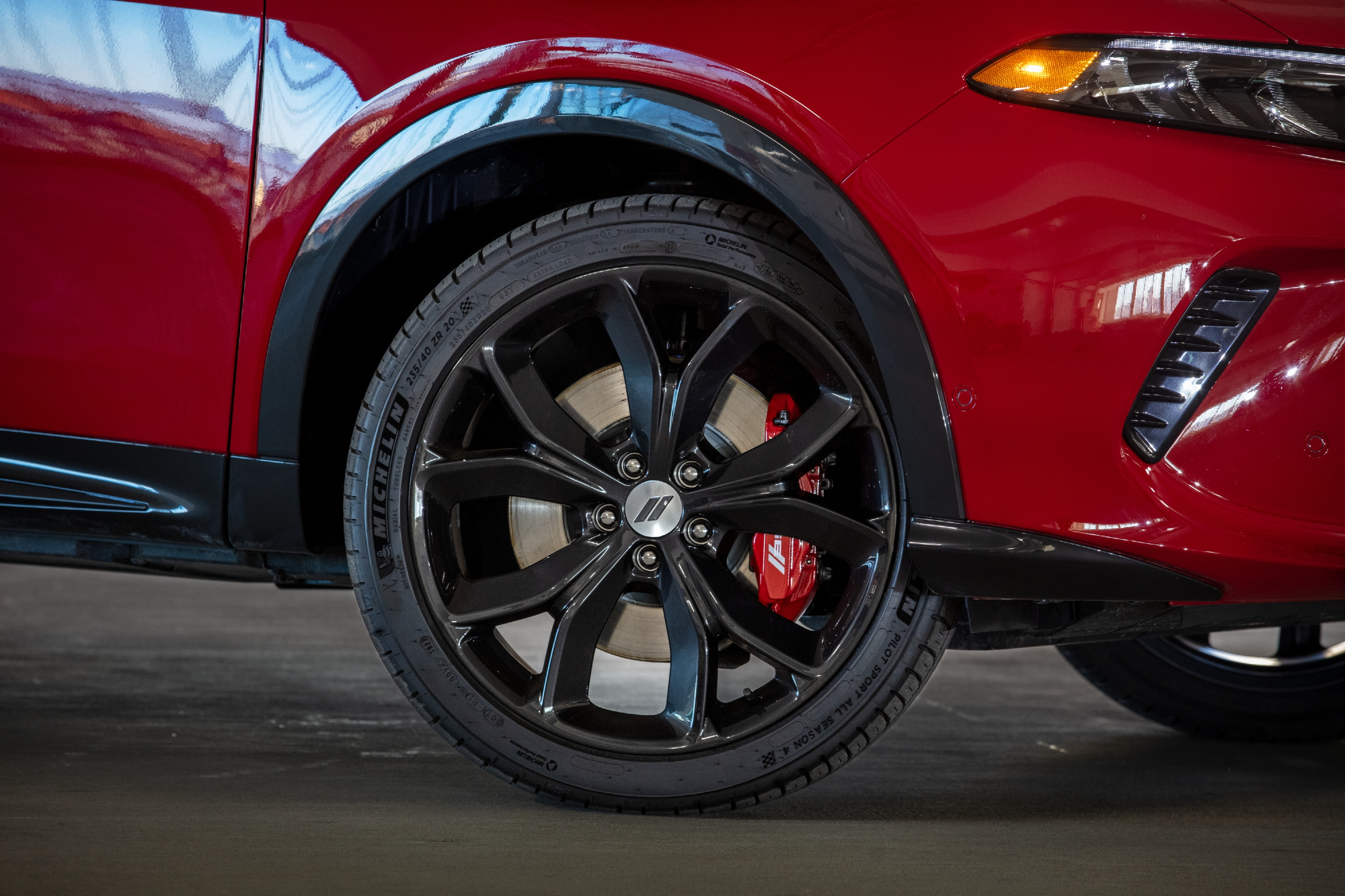 Red 2024 Dodge Hornet RT closeup shot of the right front wheel with red brake caliper and Michelin Sport Pilot tire.