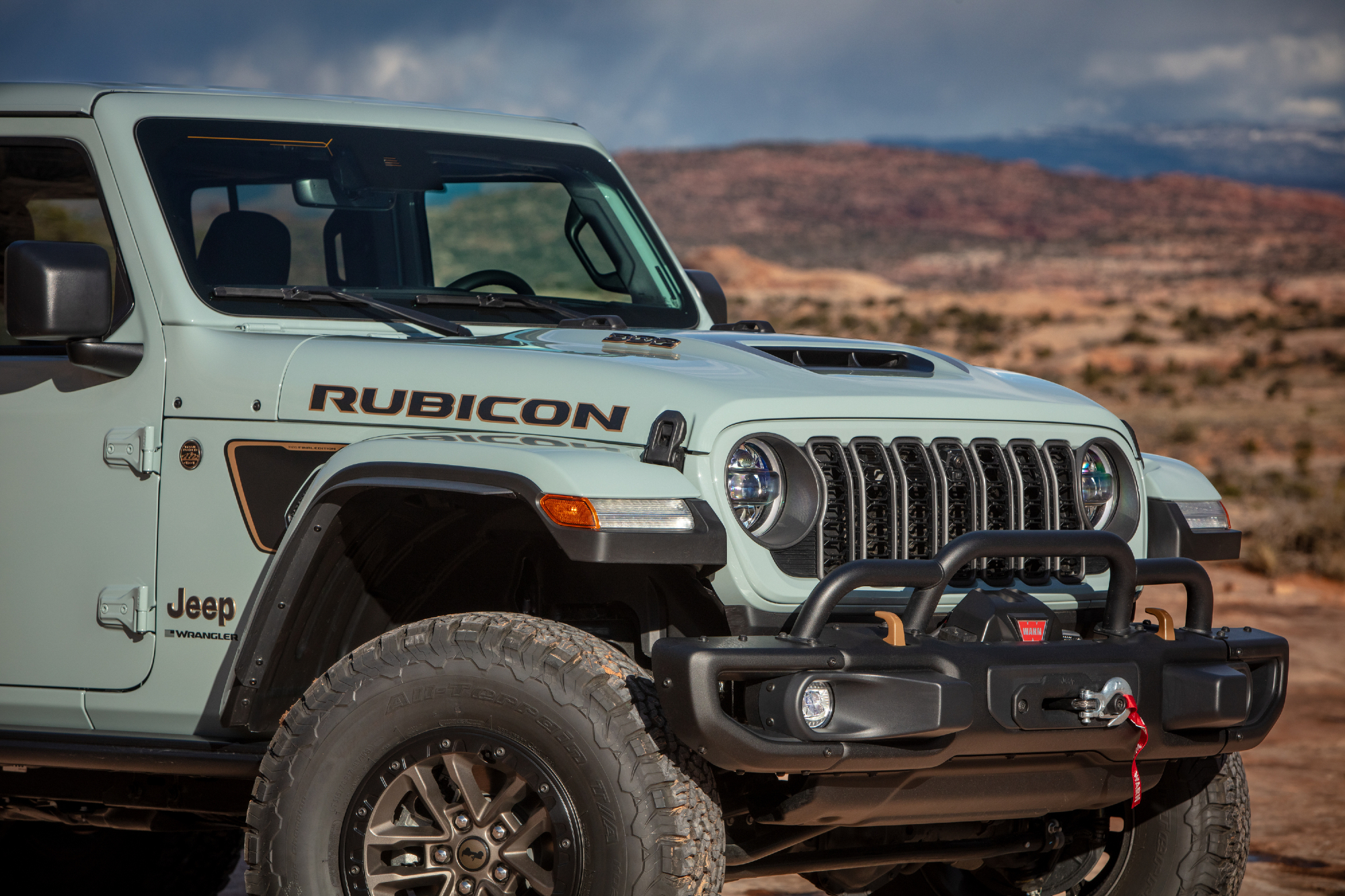 Right front side of a light blue 2024 Jeep Wranger Rubicon 392 Final Edition driving in the desert.