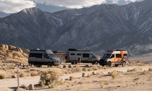 Three Outside Van camper vans parked in the desert.