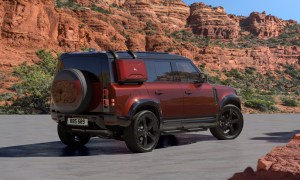 2025 Defender 110 Sedona Edition parked on desert sand with rocky hills in the background right rear three-quarter view