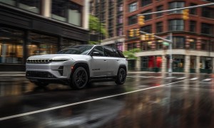 Jeep Wagoneer S Launch Edition driving on a rainy wet city street.