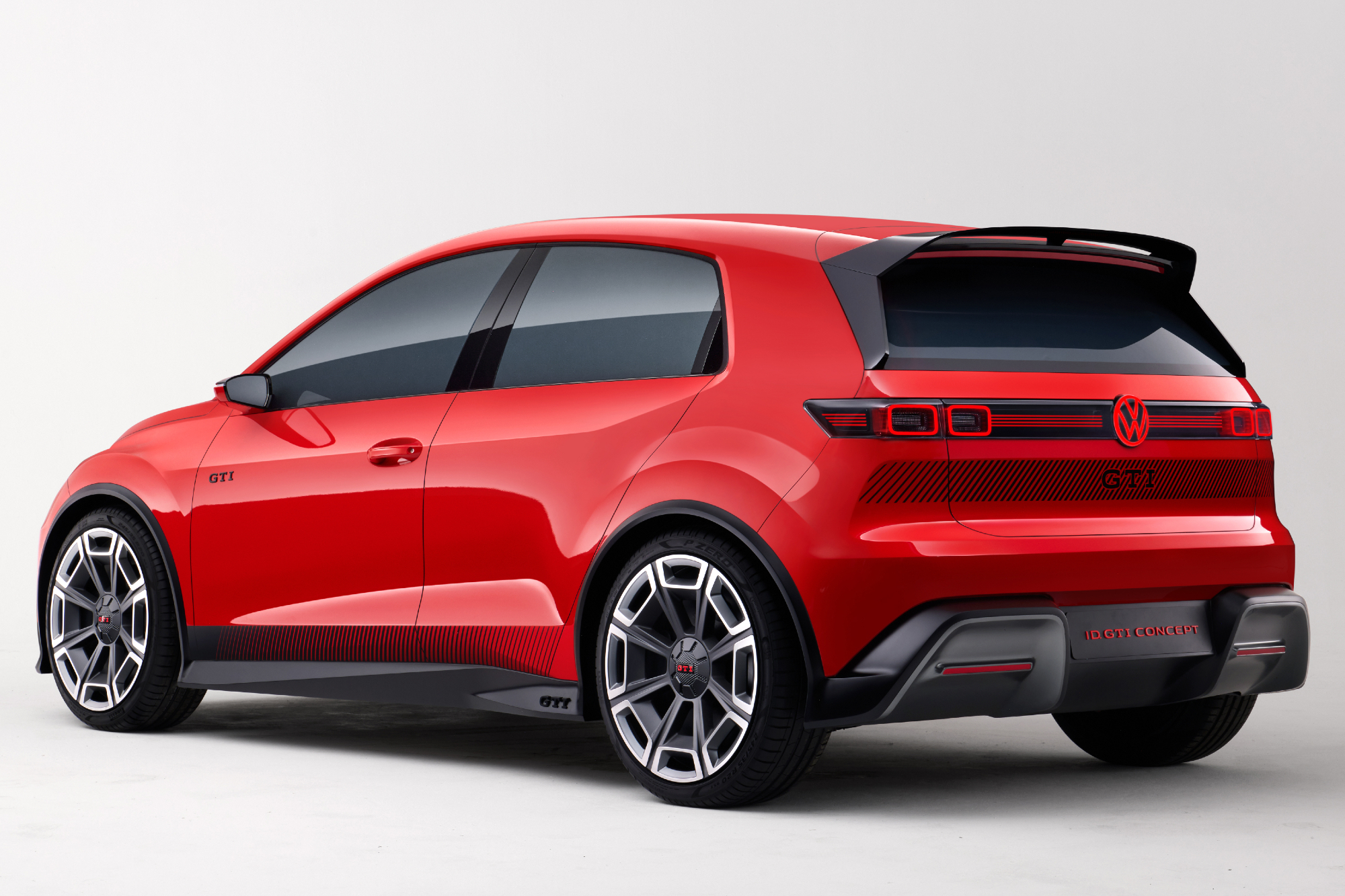 Volkswagen GTI EV concept in red left rear three-quarter view against a light gray gradient background.