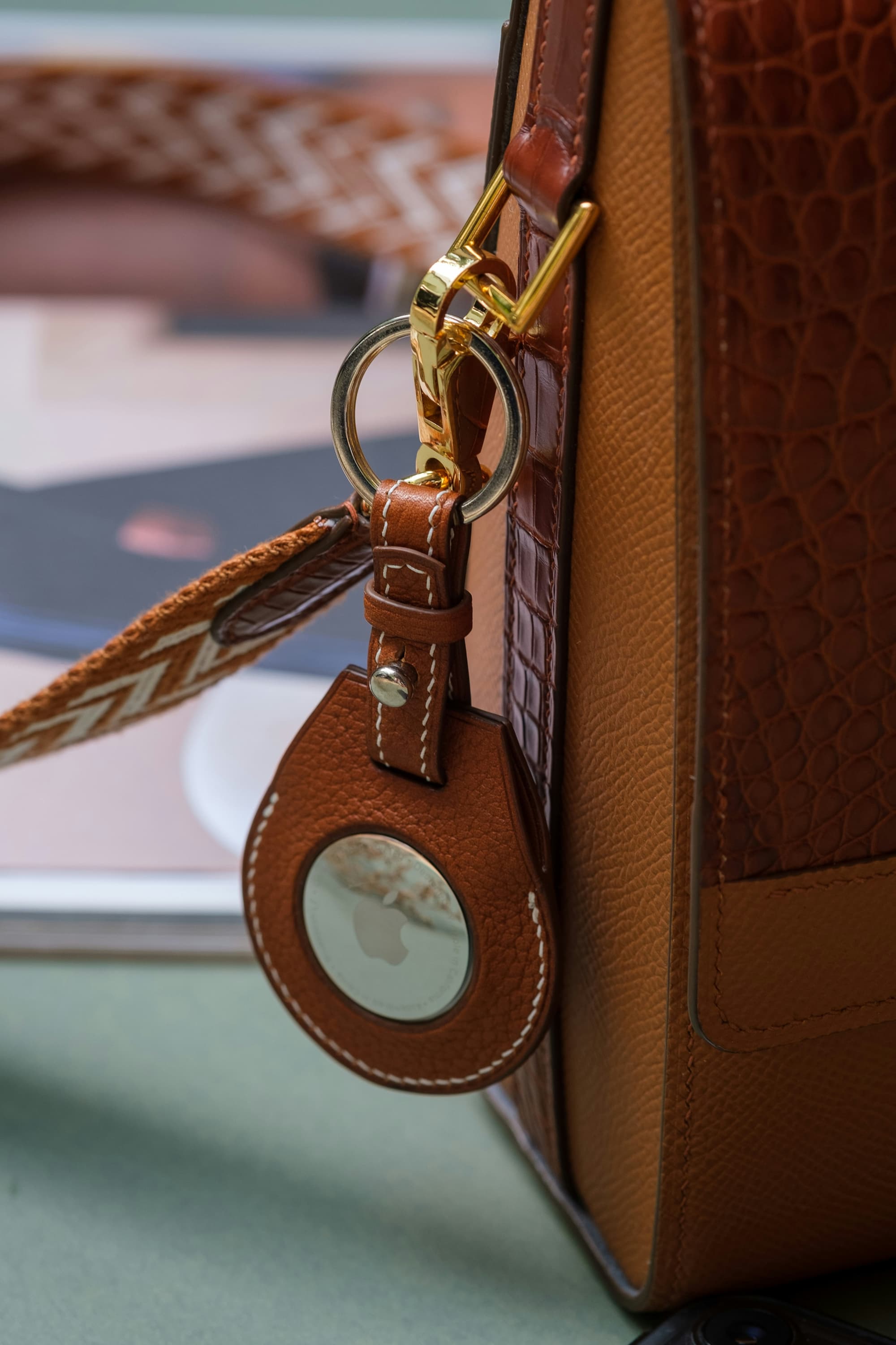 brown purse with an AirTag attached to it