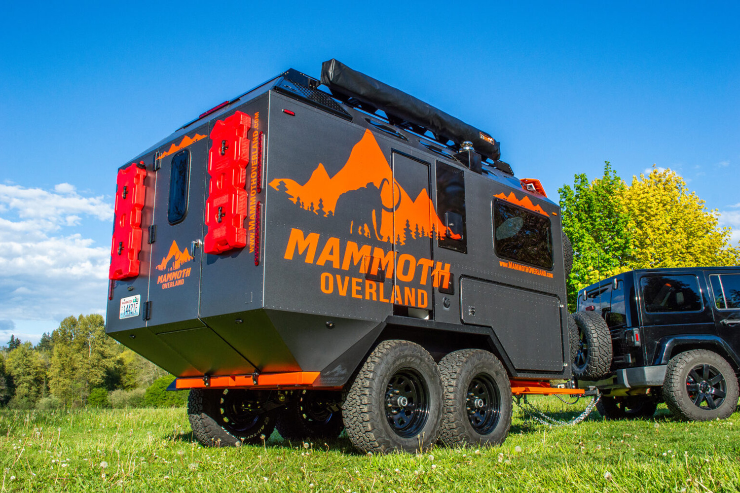 Mammoth Overland TL Travel Trailer being towed by a black Jeep Wrangler.