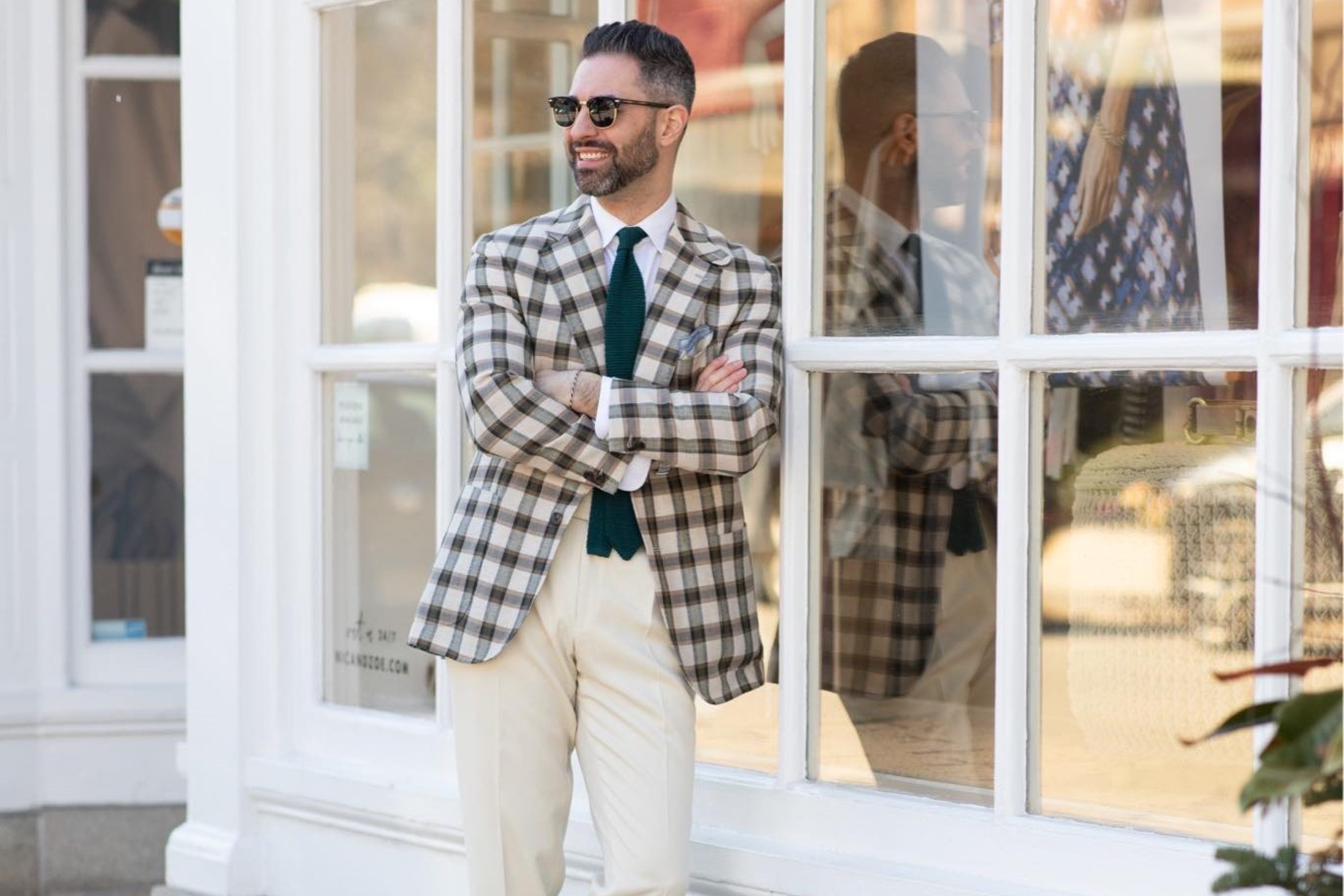 man in suit and tie leaning on building