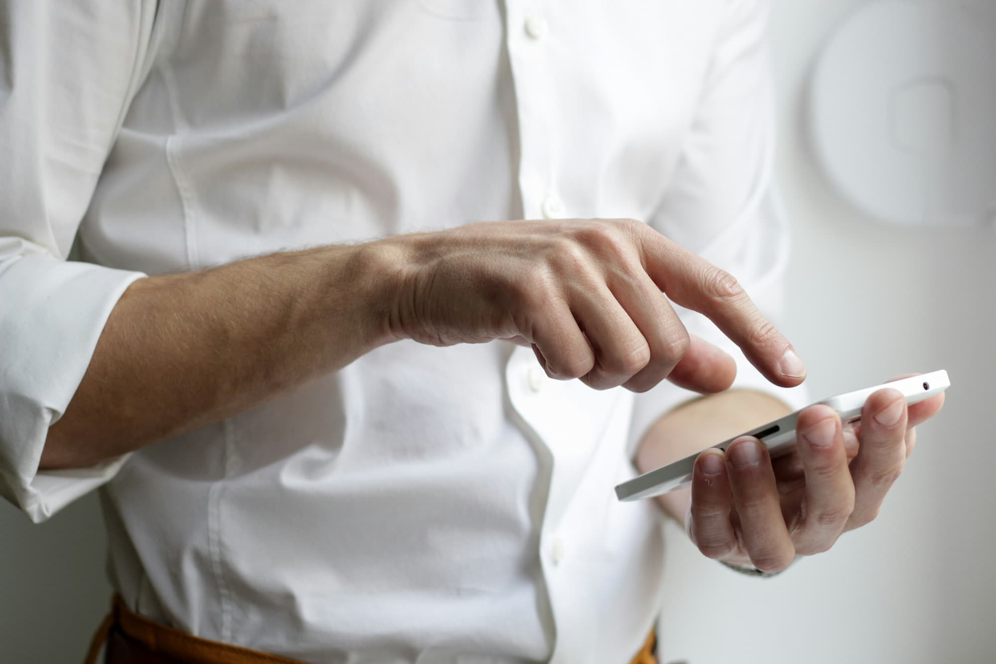 man holding smartphone in white shirt