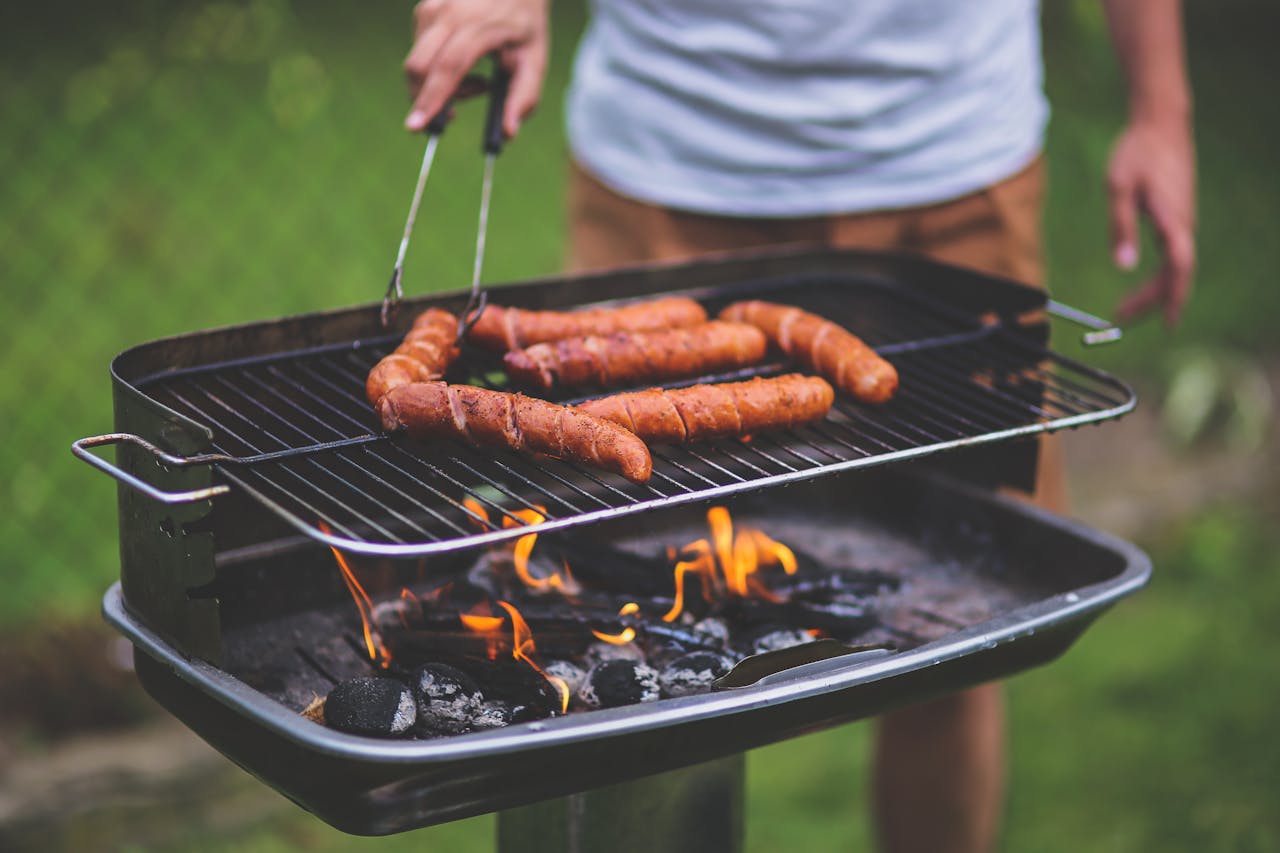 Person grilling sausages