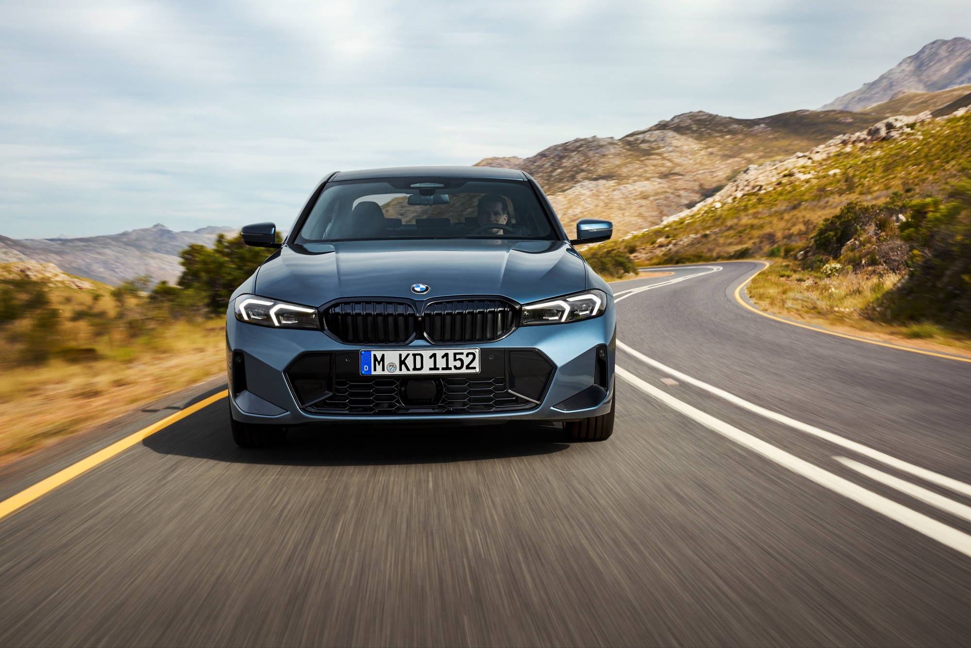 2025 BMW 3 Series direct front view driving on a mountain road.