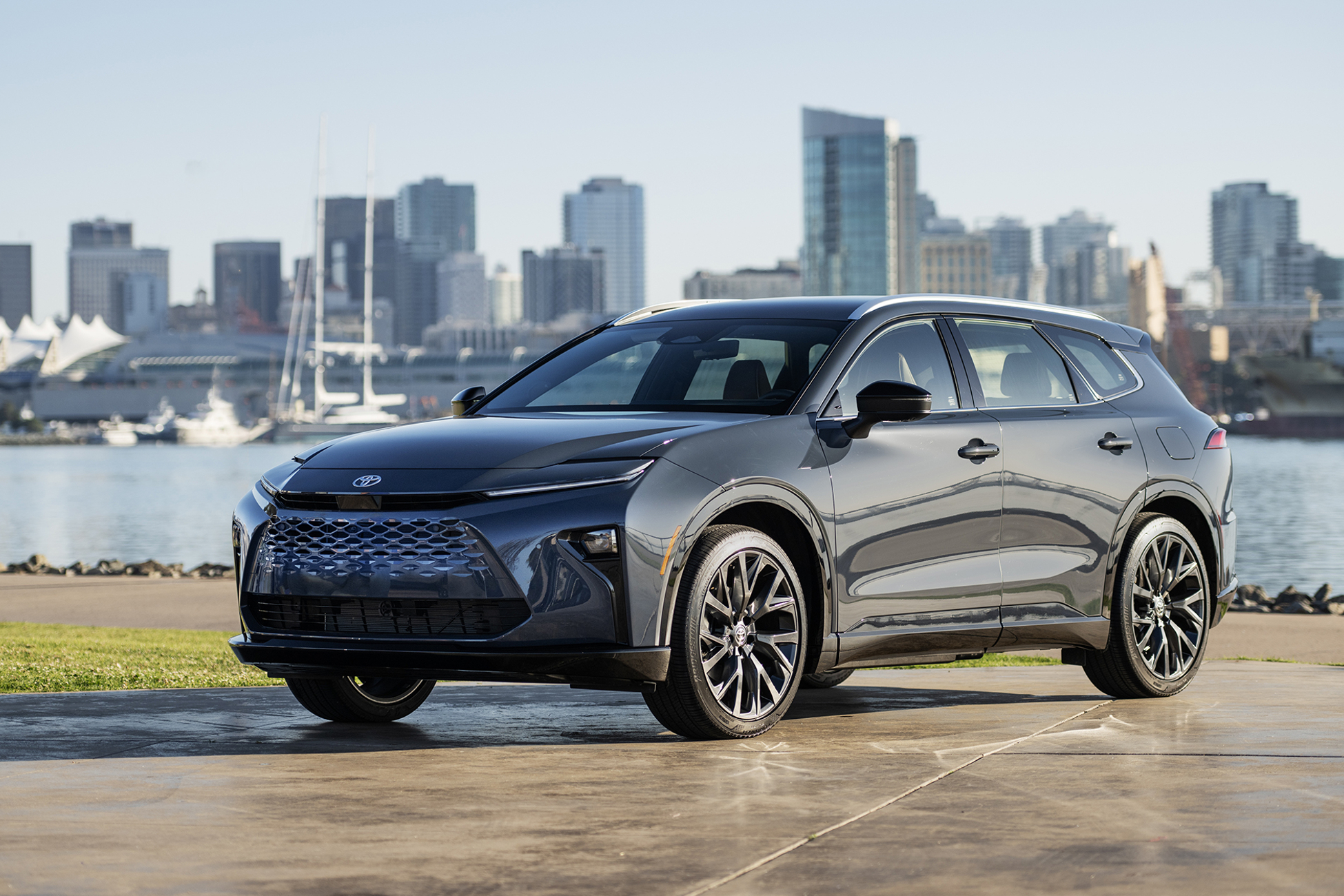 2025 Toyota Crown Signia Limited with Storm Cloud exterior parked on a wet stone parking area with river and cityscape in the background