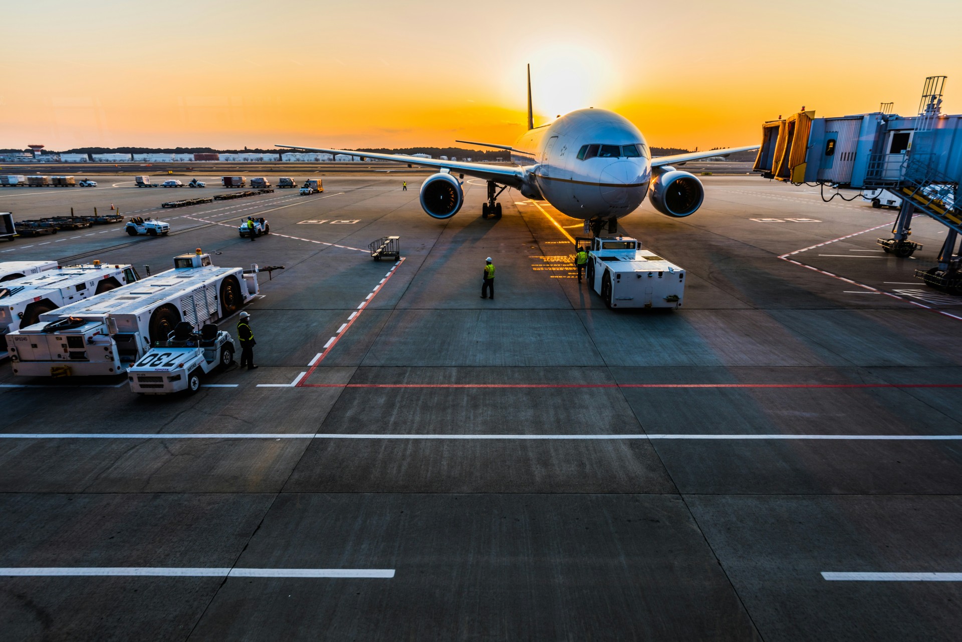 Airplane waiting at the gate as the sun rises