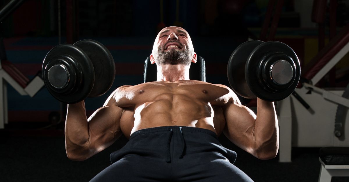 man lifting dumbbells while laying down