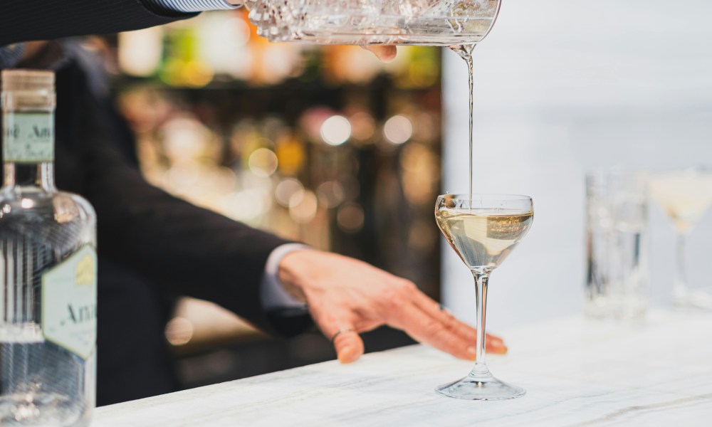 Bartender pouring drink into cocktail glass