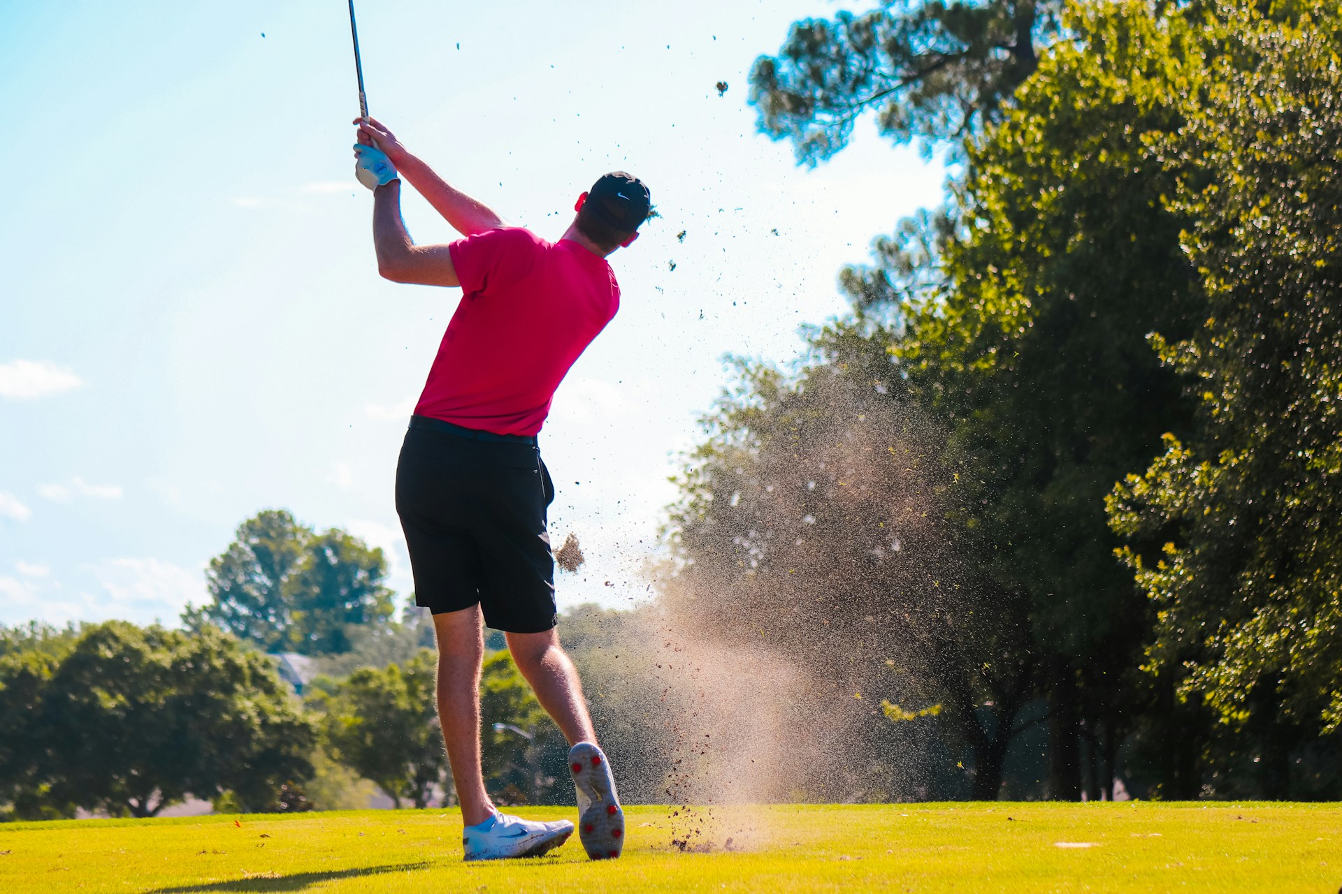 A person taking a swing on the golf course.