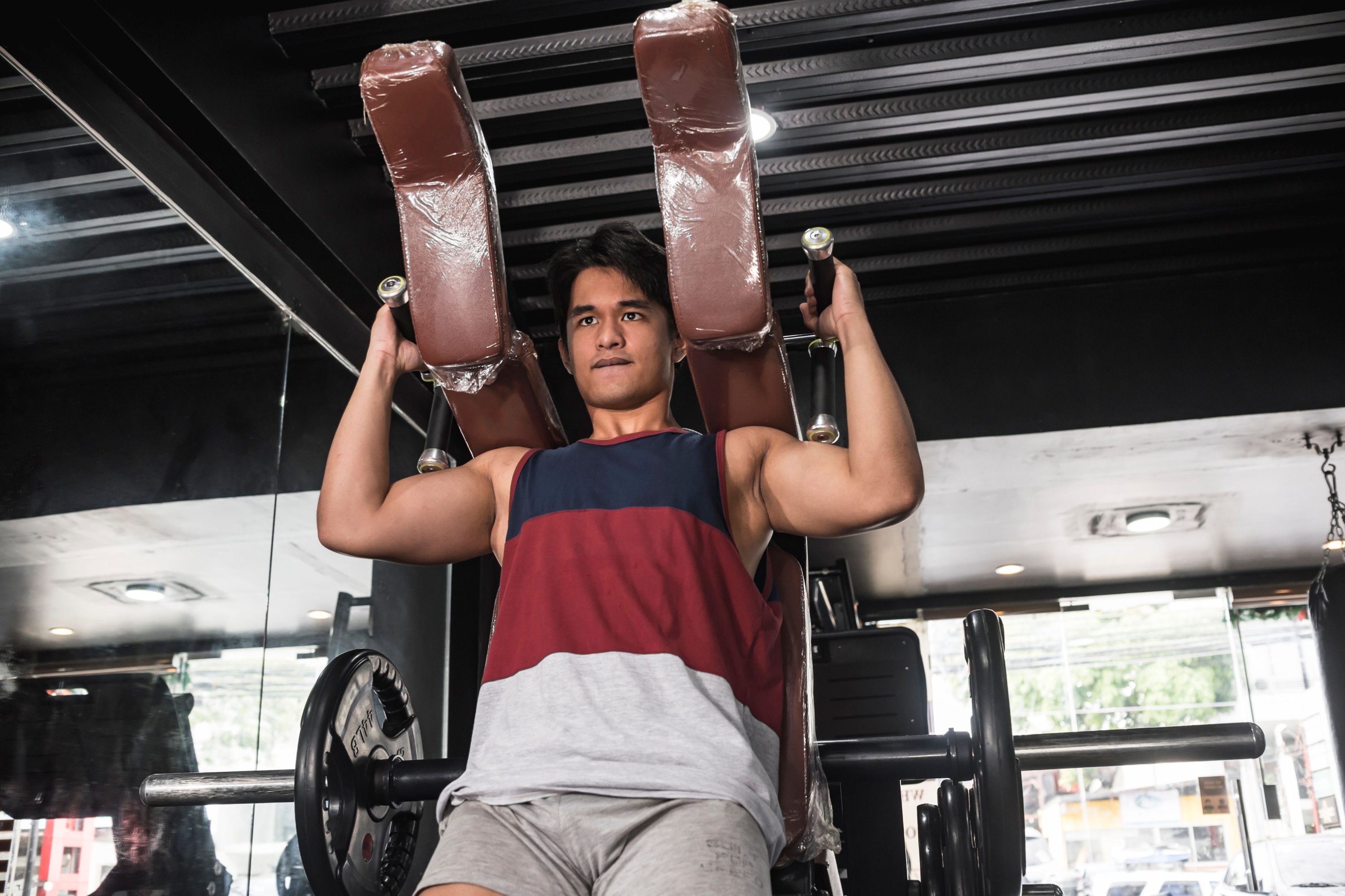 A young and handsome man working out legs by doing some hack squats at the gym.