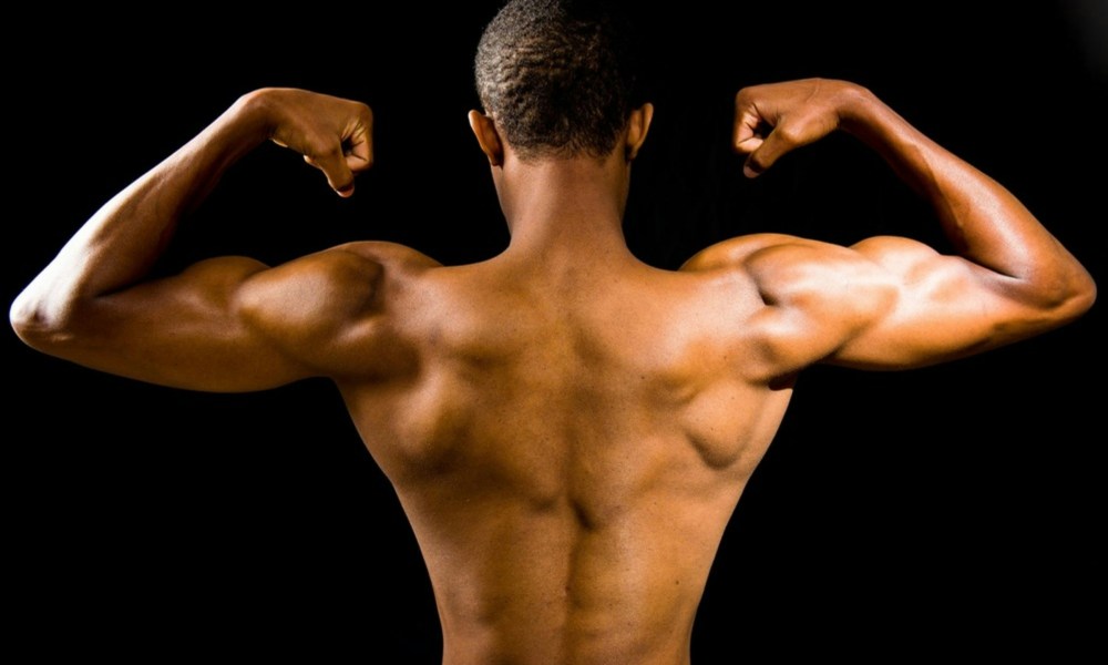 topless man back muscles flexing muscles with black background