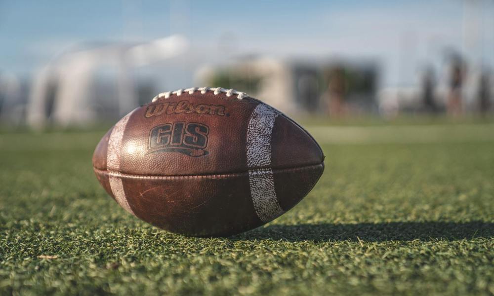 American football laying on grass