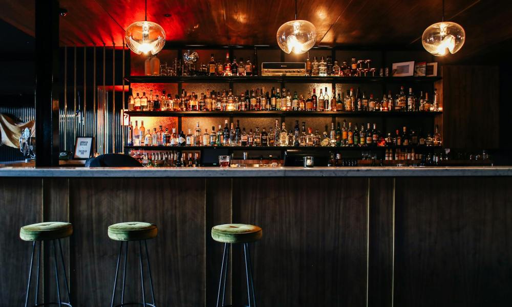 Dark bar with three empty barstools