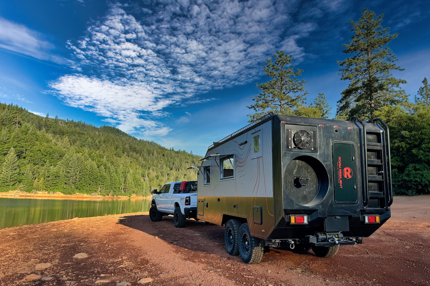 A Roam Resilient Baja Edition overland trailer parked by a lake.