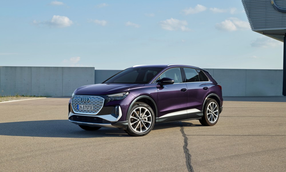 audi q4 35 e tron 2025 parked on a rooftop area with concrete wall and blue sky in the background front left three quarter vi