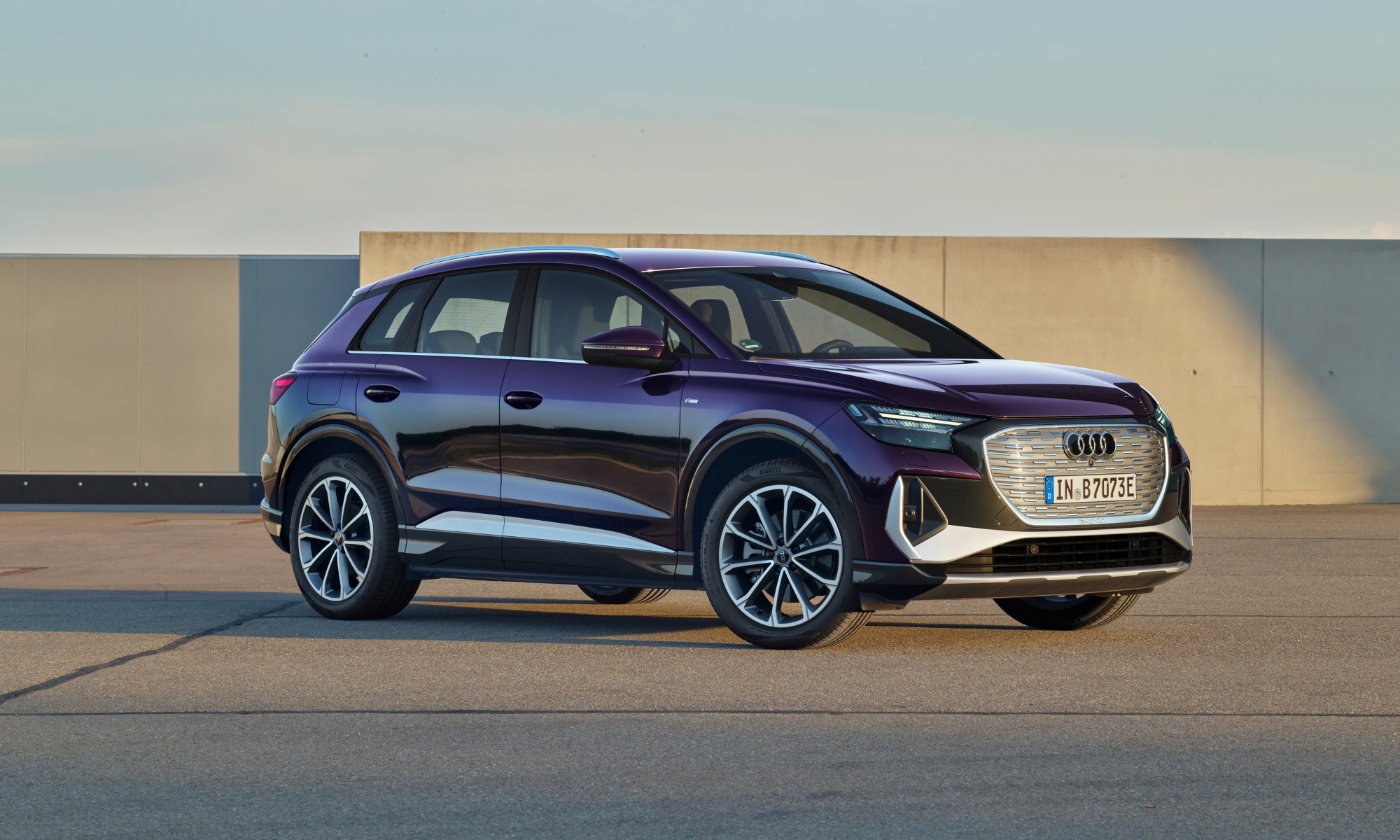 audi q4 35 e tron 2025 parked on a rooftop area with concrete wall and blue sky in the background front right three quarter v