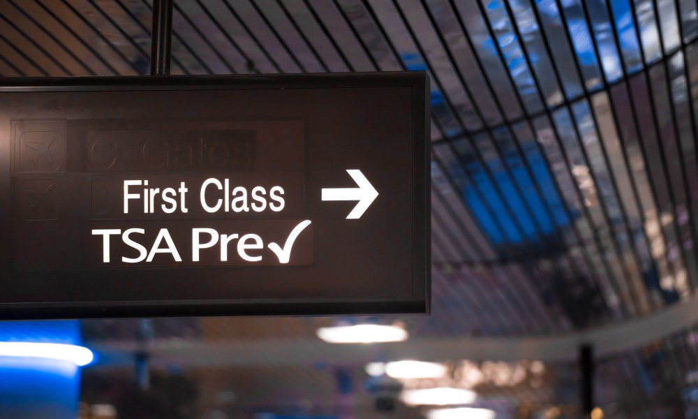 Overhead sign showing security check point lanes designated for first class and TSA Precheck passengers.